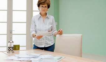 woman reading piece of paper standing at table