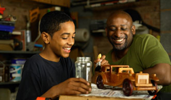 man and boy painting model car together