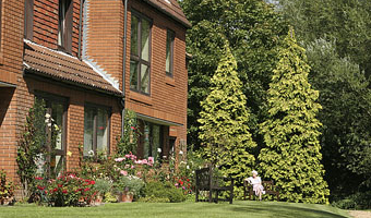 exterior of large building surrounded by flowers and trees